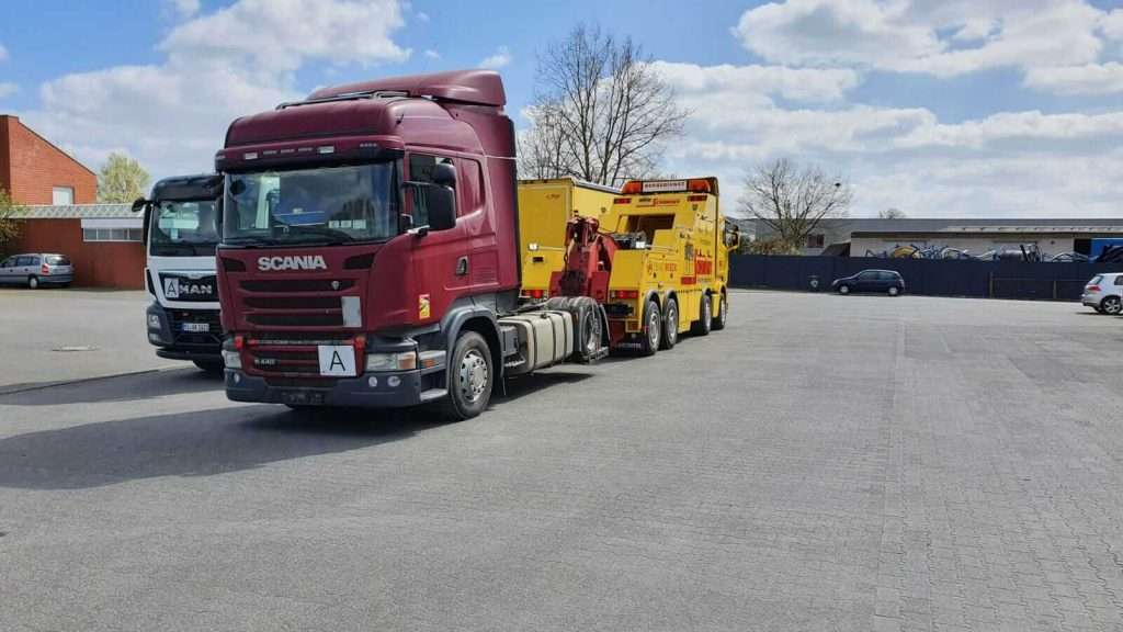 Defekte Sattelzugmaschie von der Autobahn zum Parkplatz geschleppt