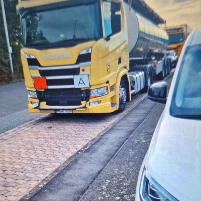 Gelber Scania LKW mit Kühlerschaden steht auf einem Autobahn-Rastplatz vor der mobilen Reparatur durch TruckBear